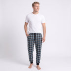 Man i blå- och grårutiga pyjamasbyxor från Gaubert med rymliga ben, elastisk midja och svarta resårmuddar