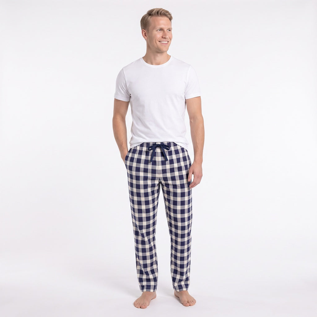 Man i blå- och vitrutiga pyjamasbyxor från Gaubert med ledig passform, sidofickor och raka benslut