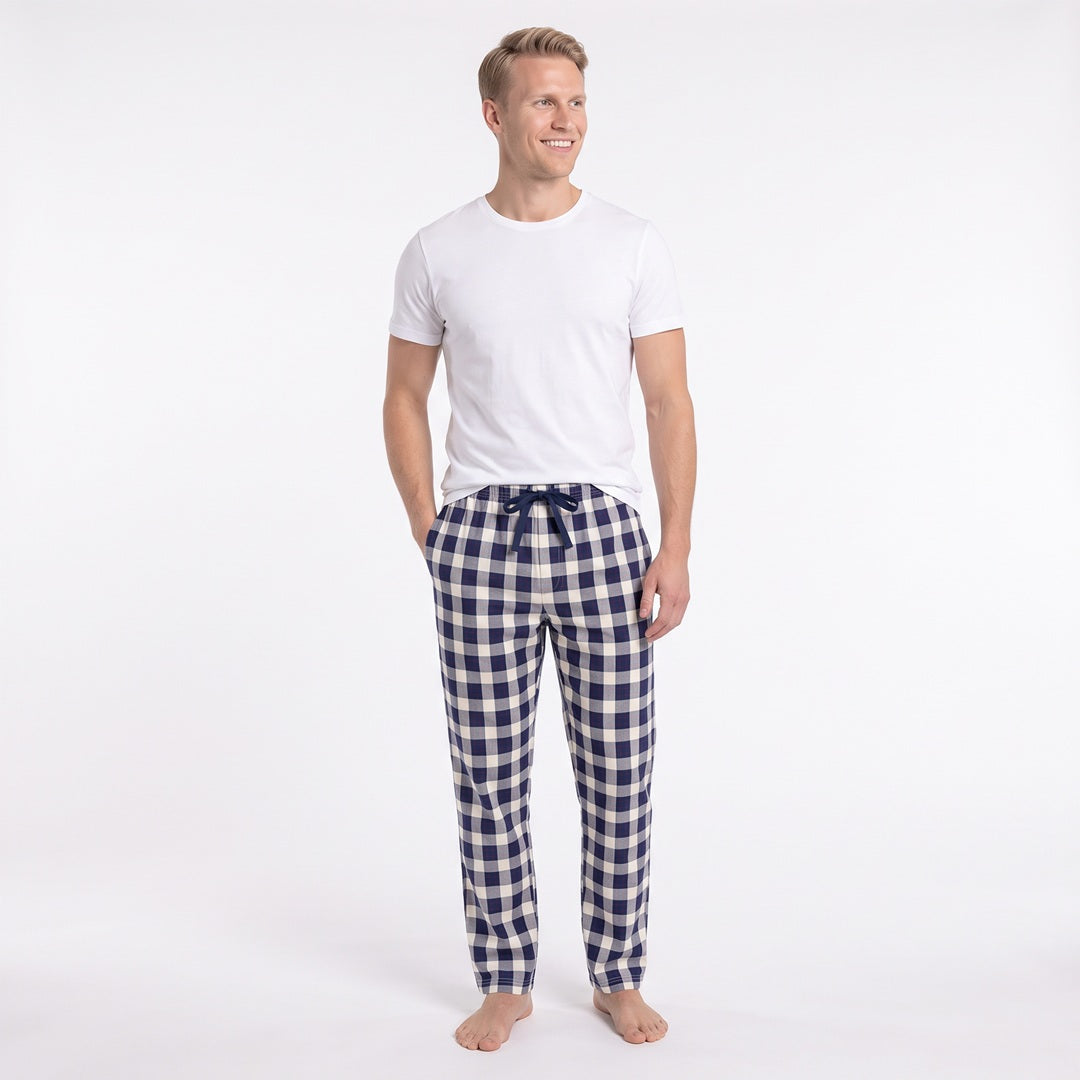 Man i blå- och vitrutiga pyjamasbyxor från Gaubert med ledig passform, sidofickor och raka benslut