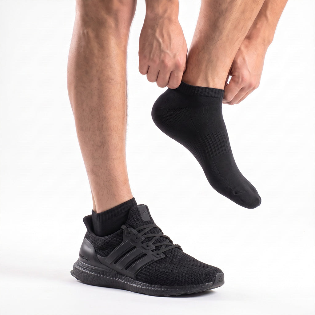 Svarta ankelstrumpor på foten till sneakers