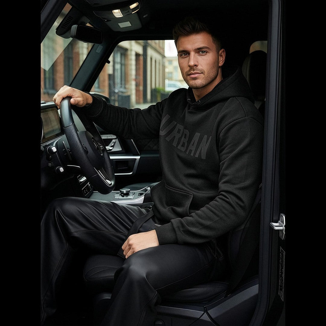 Svart Urban hoodie herr från sidan framför bil – modern streetwear sittandes