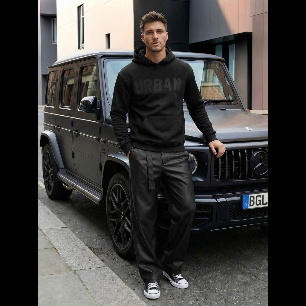 Svart Urban hoodie herr från sidan framför bil – modern streetwear stående