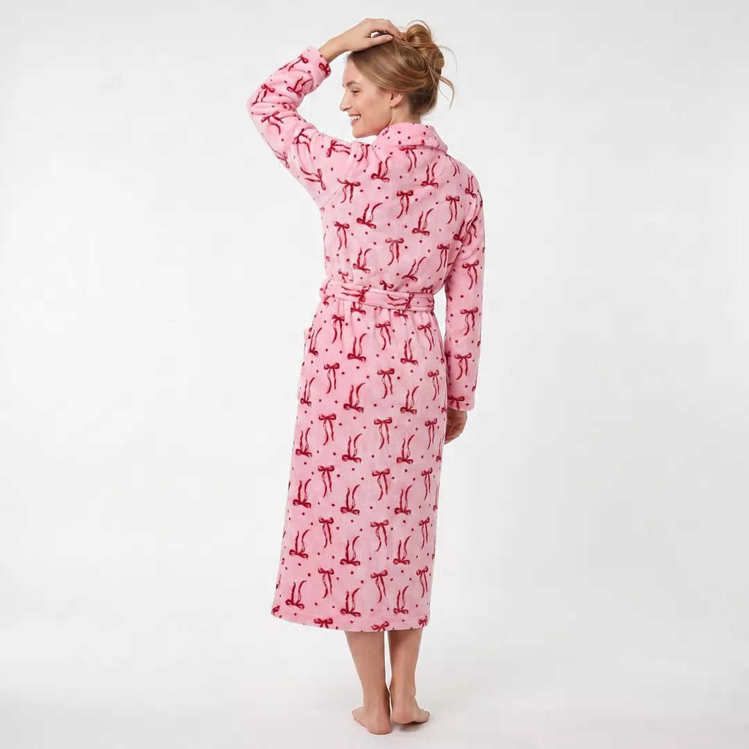 Dam bär rosa morgonrock med vinrött rosettmönster från Gaubert sedd bakifrån med lång passform och mjuk coral fleece.
