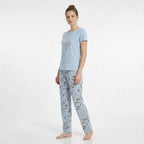 Dam bär ljusblå kortärmad pyjamas i 100% bomull med blommiga byxor