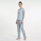 Dam bär ljusblå kortärmad pyjamas i 100% bomull med blommiga byxor