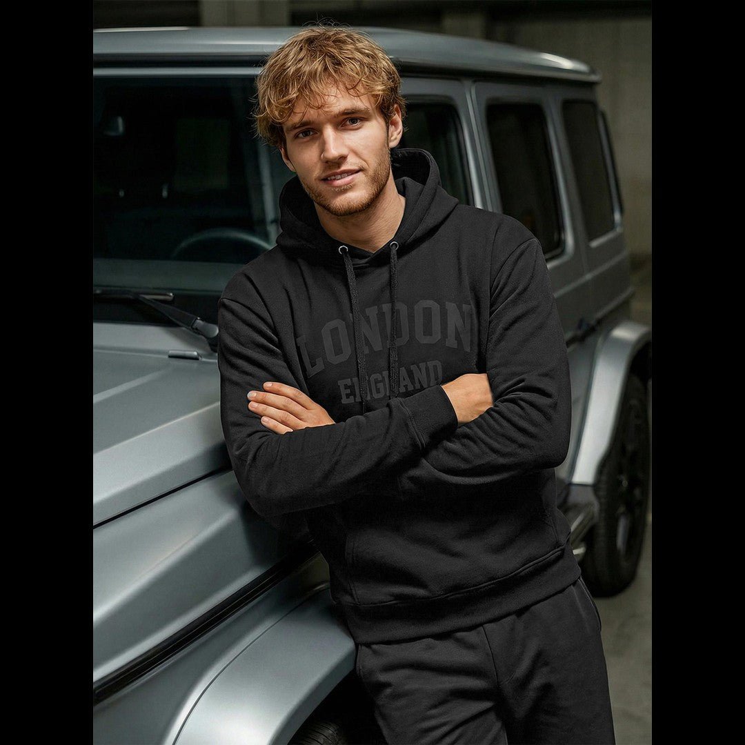 Svart hoodie herr London England framifrån urban streetwear lutad mot bild