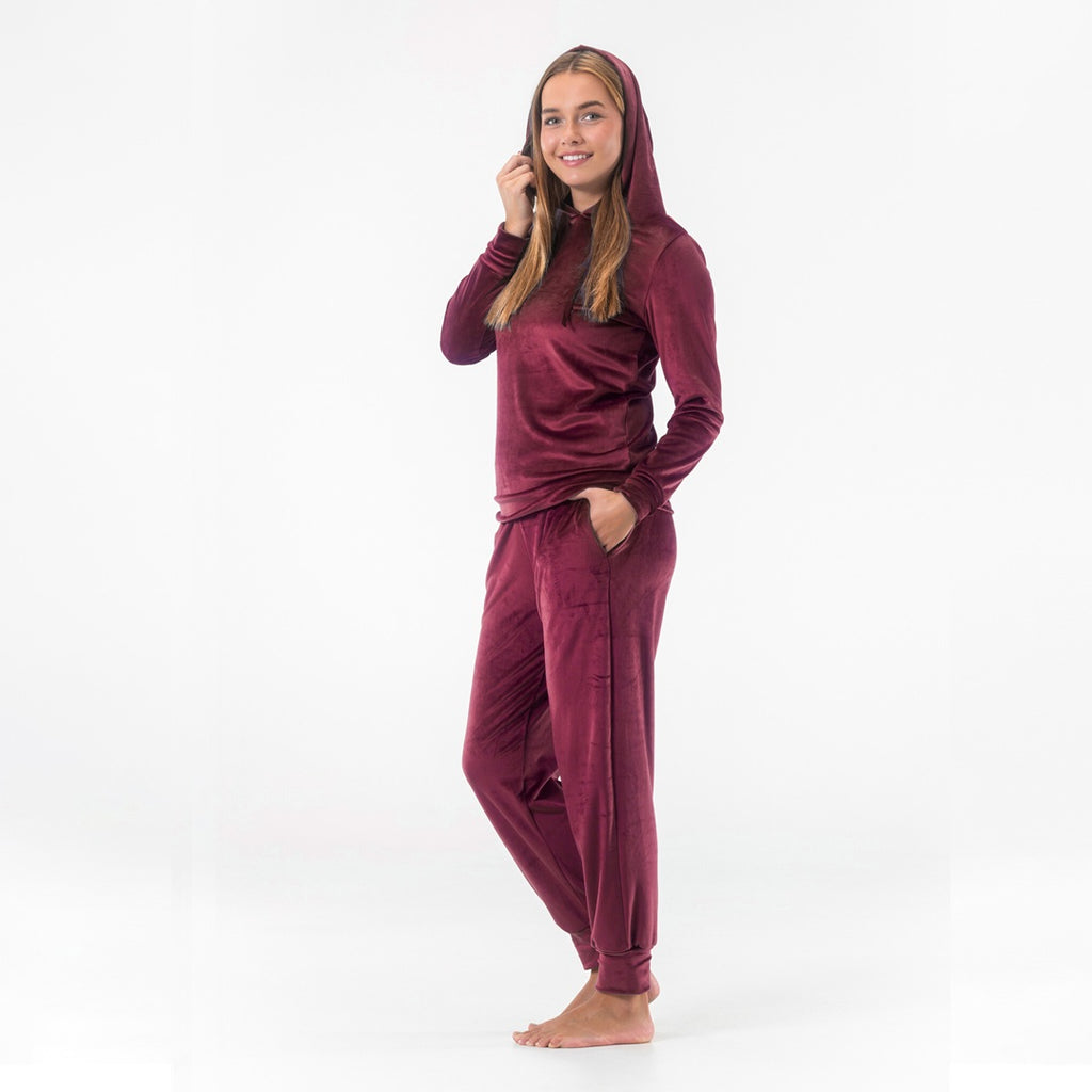 Modell i vinrött mysset dam från Gaubert med huvan uppe, pullovertröja i velour och matchande byxor