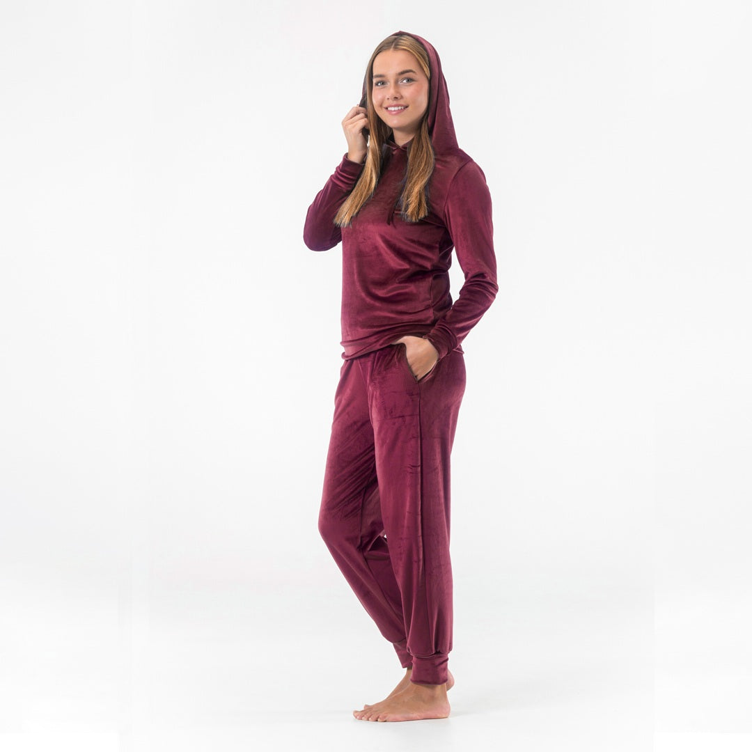 Modell i vinrött mysset dam från Gaubert med huvan uppe, pullovertröja i velour och matchande byxor